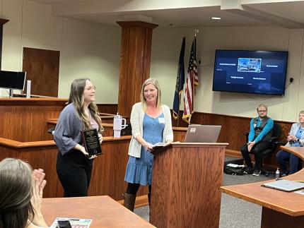 Lindsay Turner, Associate Executive Director of Voices of Hope, presents first annual Bob Moyer Award to Child and Family Services Specialist Justine Ligenza.